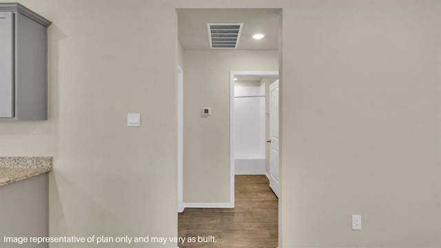 hall with baseboards, visible vents, and dark wood-style flooring