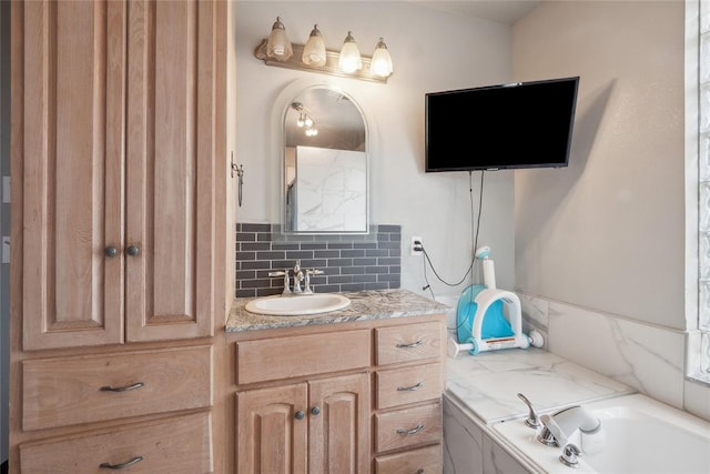 bathroom with a bathtub, backsplash, and vanity