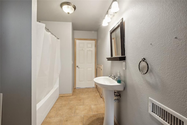 bathroom featuring tile patterned flooring and shower / bathtub combination with curtain