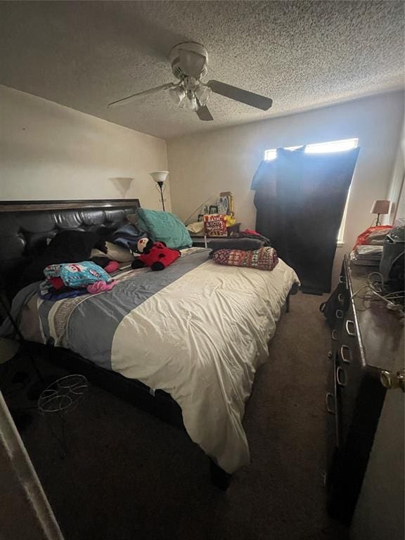 bedroom with ceiling fan, carpet, and a textured ceiling