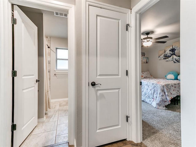 hall with light colored carpet