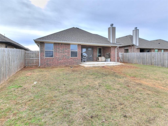 rear view of property with a yard and a patio area