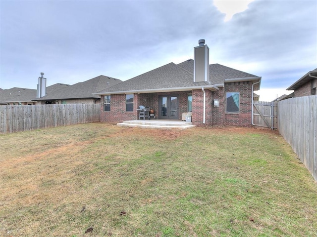 rear view of property with a lawn and a patio