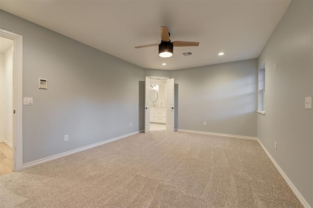 unfurnished bedroom featuring ensuite bathroom, ceiling fan, and light colored carpet