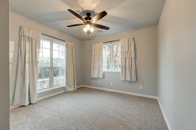 unfurnished room with ceiling fan, light colored carpet, and a textured ceiling