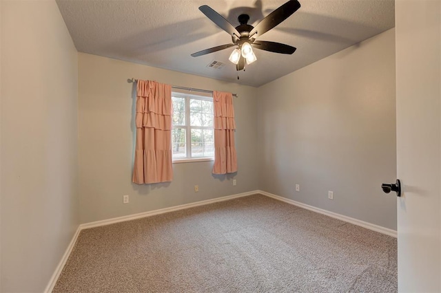 carpeted empty room with ceiling fan and a textured ceiling