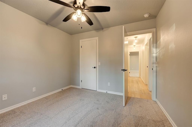 unfurnished bedroom with ceiling fan and light carpet