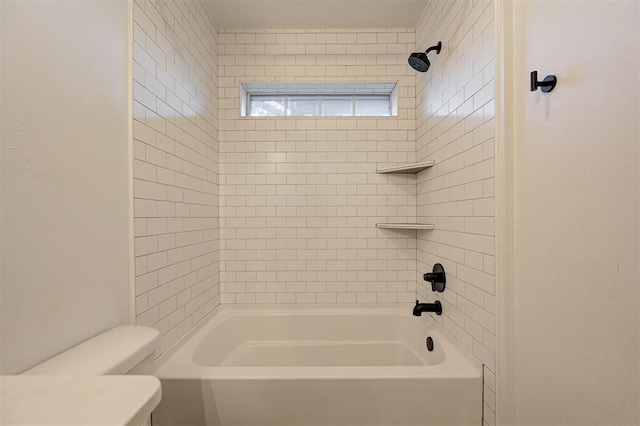 bathroom featuring toilet and tiled shower / bath