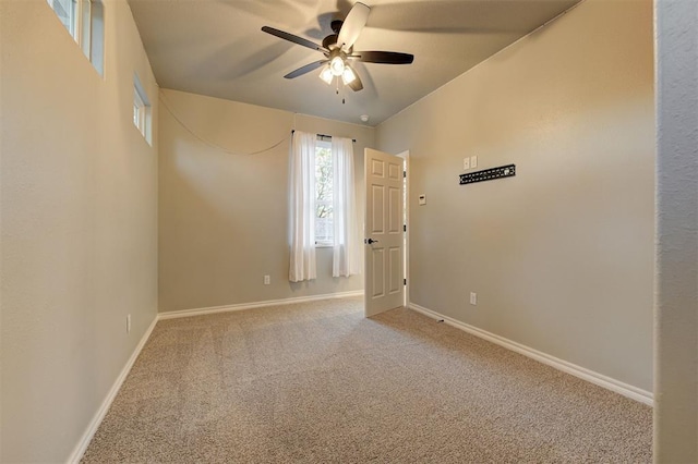 unfurnished room with ceiling fan and carpet