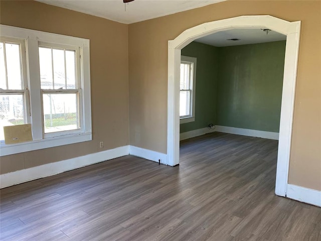 spare room featuring dark hardwood / wood-style flooring and plenty of natural light