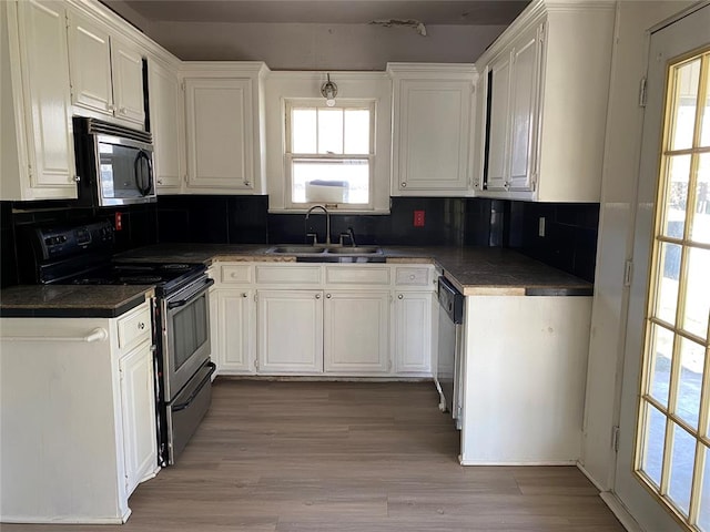 kitchen featuring white cabinets, sink, light wood-type flooring, appliances with stainless steel finishes, and tasteful backsplash