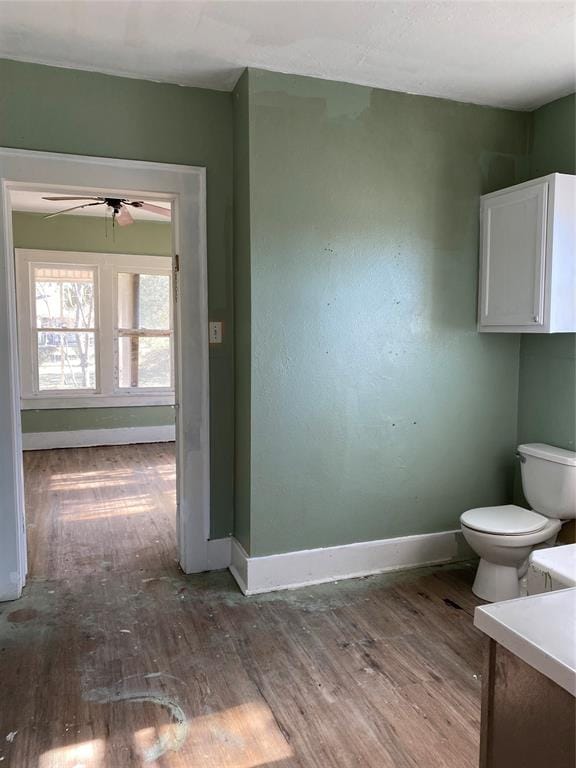 bathroom featuring ceiling fan, toilet, vanity, and hardwood / wood-style flooring