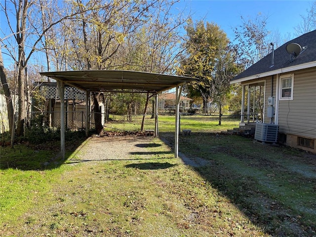 view of yard with central AC and a carport