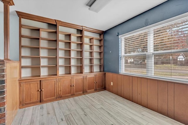 interior space with light wood-type flooring and wood walls