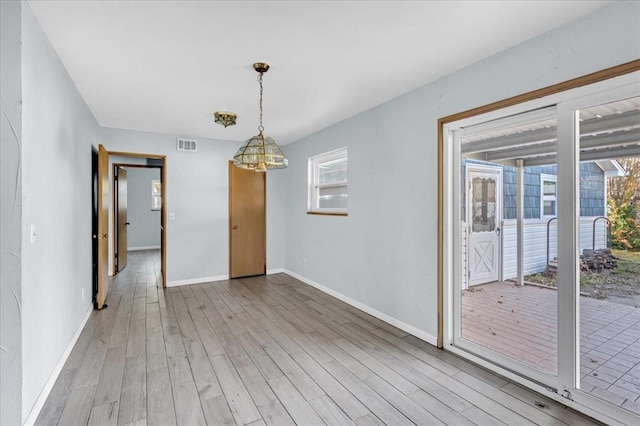 spare room with light wood-type flooring and a wealth of natural light