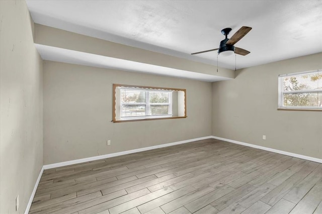 spare room featuring plenty of natural light, ceiling fan, and light hardwood / wood-style flooring