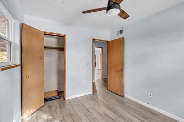 unfurnished bedroom featuring light wood-type flooring, a closet, and ceiling fan