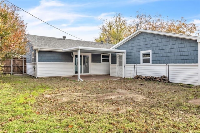 rear view of property featuring a lawn