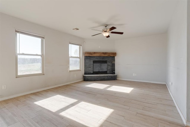 unfurnished living room featuring ceiling fan, a fireplace, and light wood-type flooring