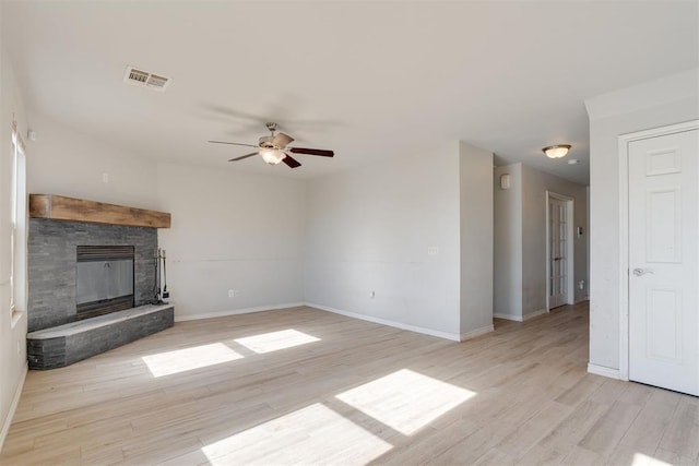 unfurnished living room with a fireplace, light wood-type flooring, and ceiling fan