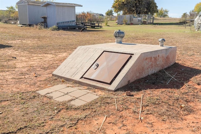 view of storm shelter featuring a yard and a storage shed