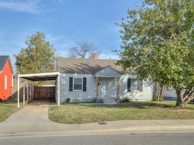 view of front of property featuring a front yard and a carport