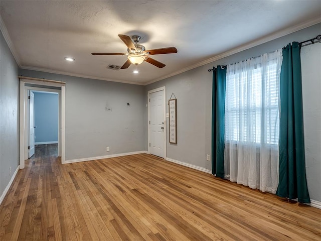 empty room featuring light wood-type flooring, ceiling fan, and crown molding