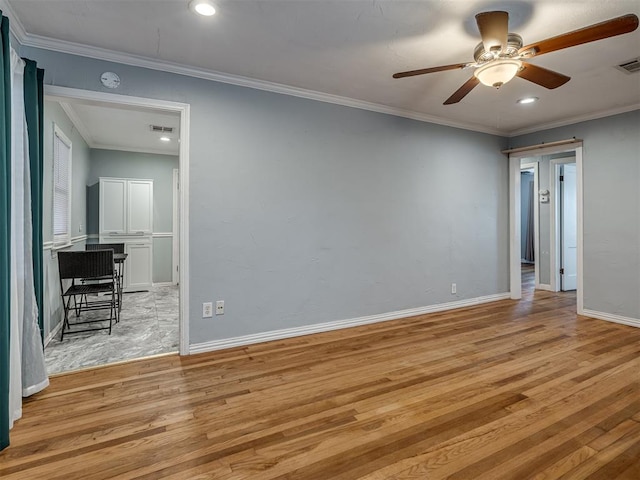 spare room featuring ceiling fan, ornamental molding, and light wood-type flooring