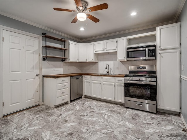 kitchen featuring white cabinetry, sink, decorative backsplash, appliances with stainless steel finishes, and ornamental molding