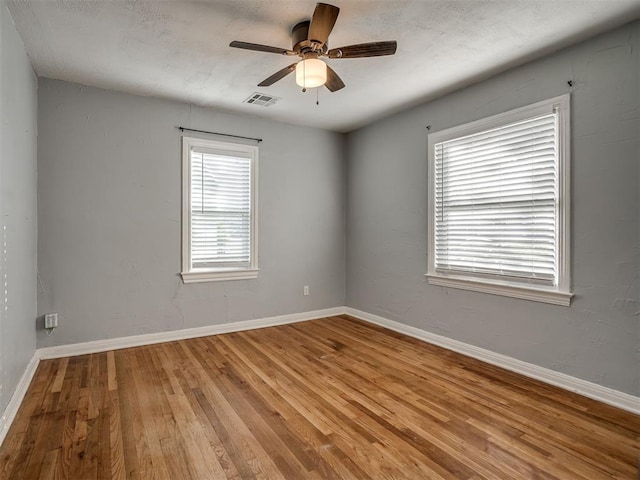 unfurnished room with ceiling fan, plenty of natural light, and light hardwood / wood-style floors