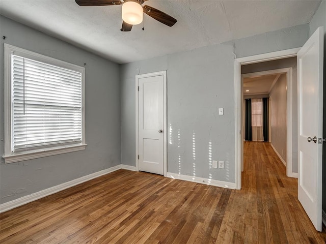 unfurnished bedroom featuring hardwood / wood-style flooring and ceiling fan