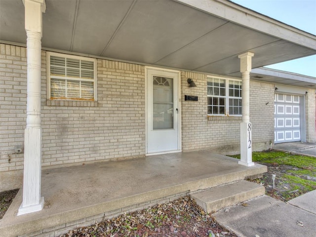 entrance to property featuring a porch and a garage