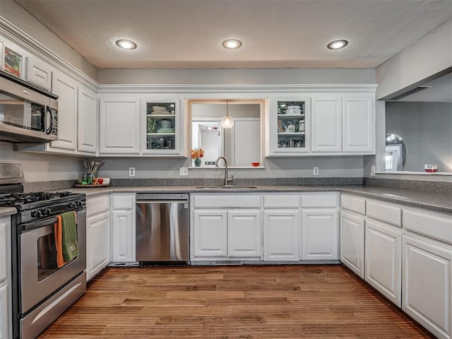 kitchen featuring white cabinetry, sink, stainless steel appliances, and light hardwood / wood-style flooring