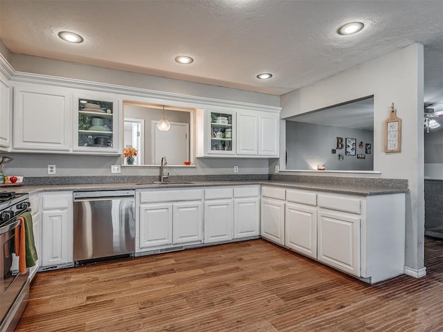 kitchen with sink, white cabinets, stainless steel appliances, and light hardwood / wood-style floors