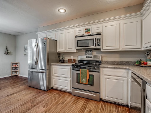 kitchen featuring white cabinets, light wood-type flooring, and stainless steel appliances