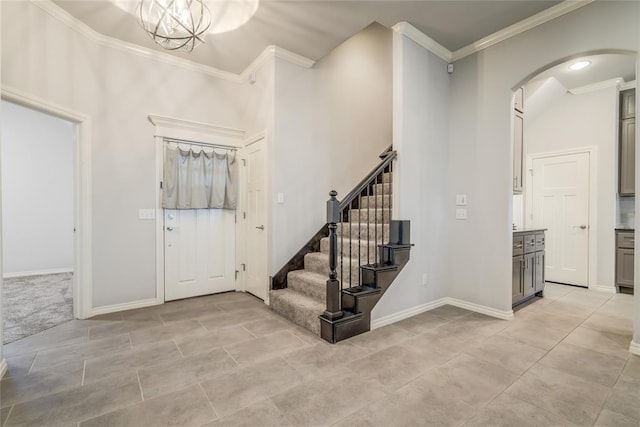 entryway with crown molding and an inviting chandelier