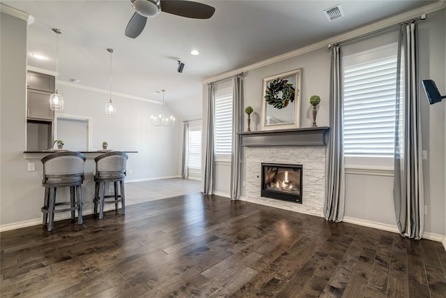 living room with crown molding, dark wood-type flooring, and a healthy amount of sunlight