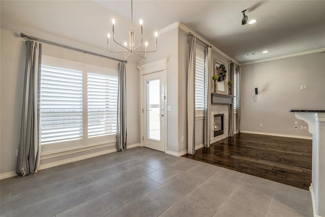 foyer entrance with ornamental molding, tile patterned floors, and a chandelier