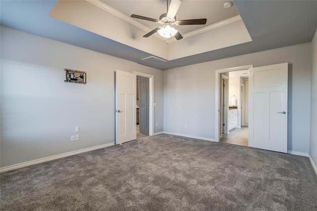 unfurnished bedroom with crown molding, light carpet, ceiling fan, and a tray ceiling