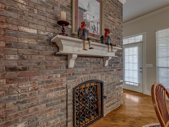 room details with hardwood / wood-style flooring, ornamental molding, and a fireplace