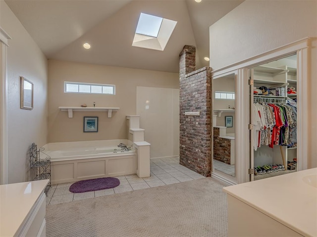 bathroom featuring vanity, vaulted ceiling, tile patterned floors, and a bathing tub