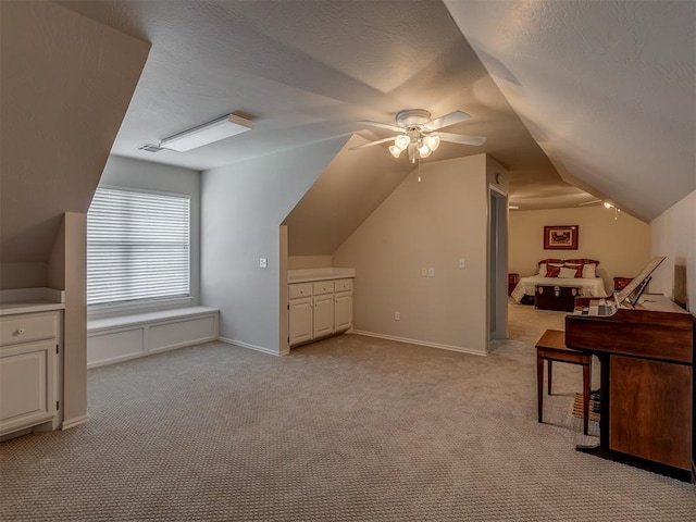 bonus room with vaulted ceiling, light colored carpet, and a textured ceiling