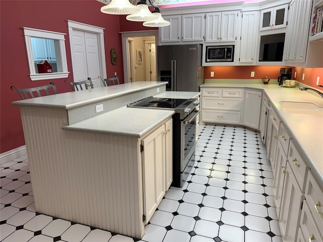 kitchen with a kitchen island, decorative light fixtures, sink, a breakfast bar area, and stainless steel appliances