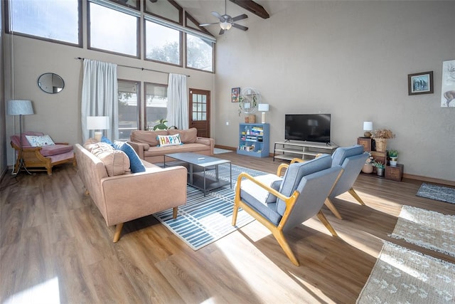 living room with hardwood / wood-style flooring, ceiling fan, beam ceiling, and high vaulted ceiling