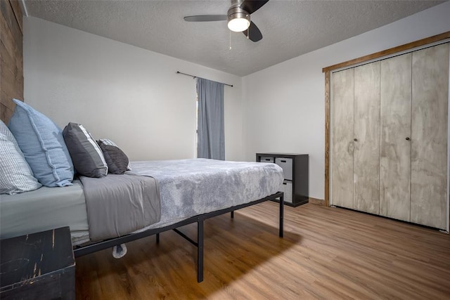 bedroom featuring a closet, a textured ceiling, hardwood / wood-style flooring, and ceiling fan