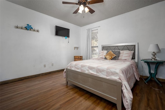 bedroom featuring ceiling fan, wood-type flooring, and a textured ceiling