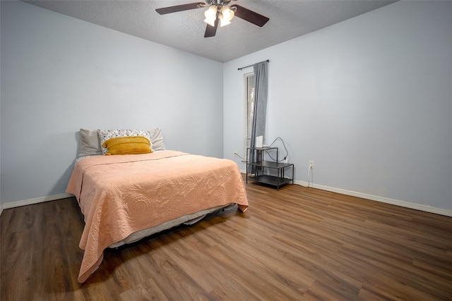 bedroom featuring ceiling fan, dark wood-type flooring, and a textured ceiling