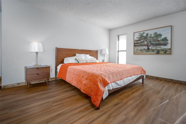 bedroom featuring dark hardwood / wood-style flooring and a textured ceiling