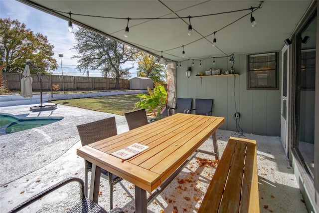 view of patio / terrace with a pool and a storage shed