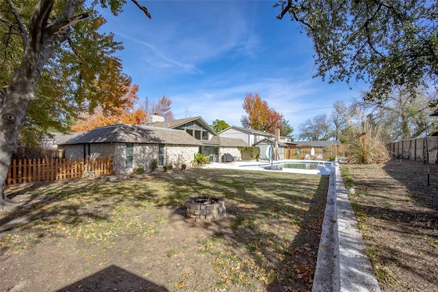 view of yard with a fenced in pool and an outdoor fire pit